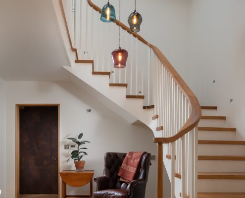Entrance hall with a view of the stairs circling around the chandelier